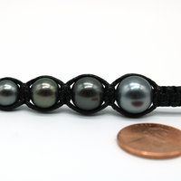 Tahitian pearl size comparison in macrame weave — 8mm, 9mm, 10mm, and 11mm pearls with penny for scale