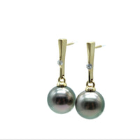 Pearl earrings with gold posts and lab grown diamonds on a white background