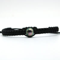 Black cord bracelet with a pearl on a white background