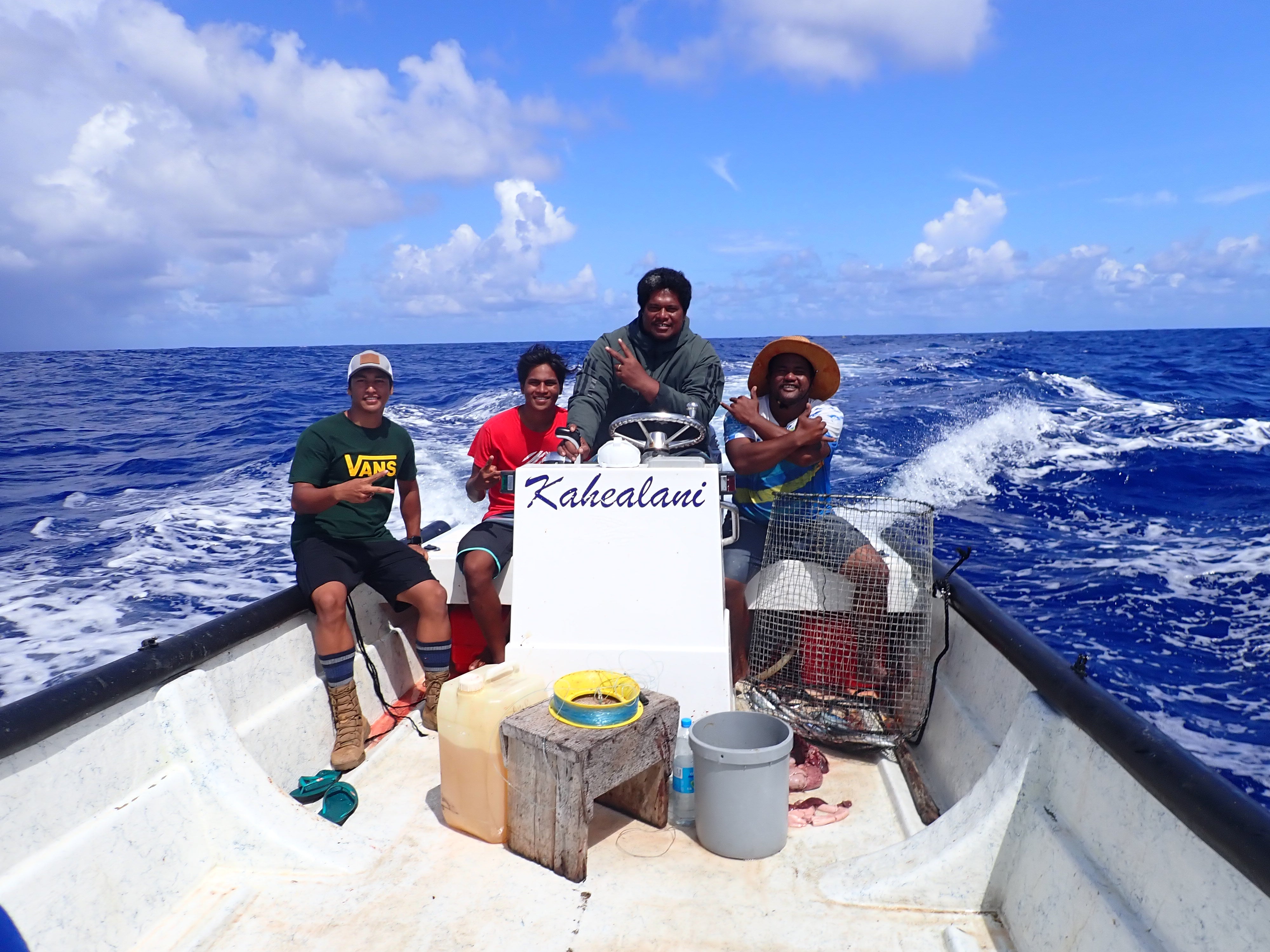 Four men giving peace signs as they cruise on the ocean in a boat