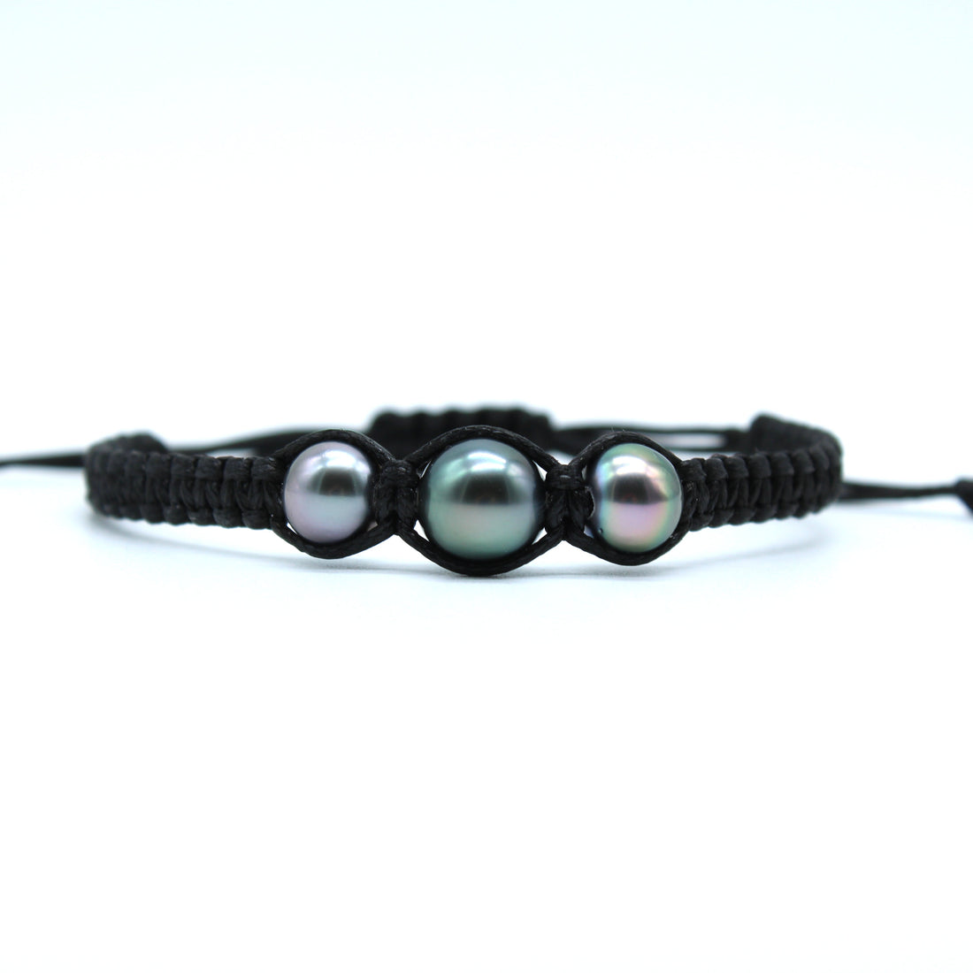 A black macrame bracelet featuring three round, iridescent greenish-black pearls displayed on a clean white background.