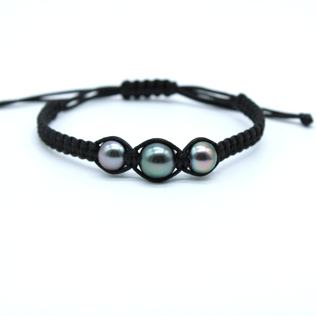 A black macrame bracelet featuring three small iridescent pearls, displayed on a clean white background.