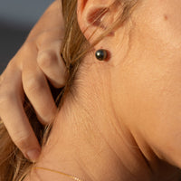 Photo of a woman wearing a pair of Tahitian Black Pearl Stud Earrings