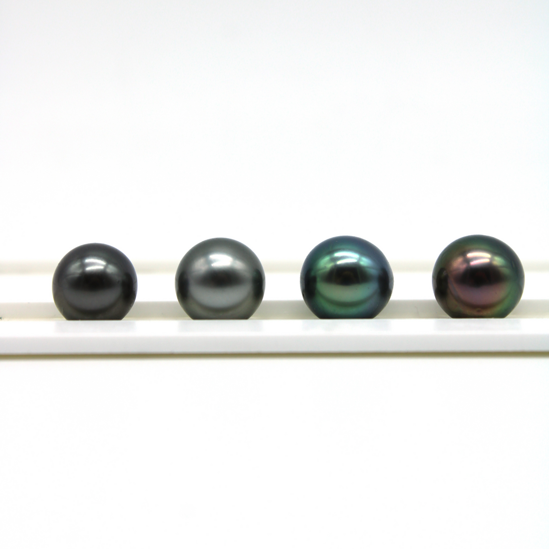Tahitian pearl color comparison — Dark/Black, Light/Silver, Blue Green, and Peacock pearls side by side