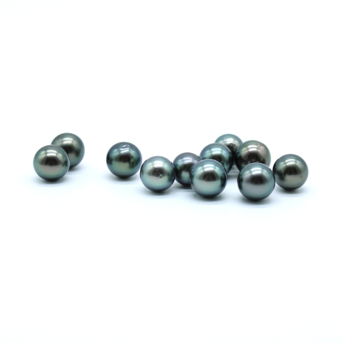 Blue Green Tahitian black pearls on a white background