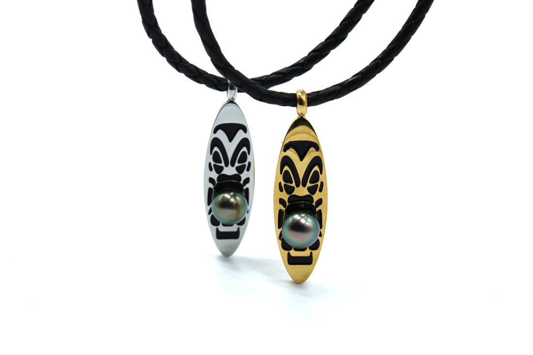 Two necklaces with black cord and decorative pendants featuring tahitian black pearls on a white background
