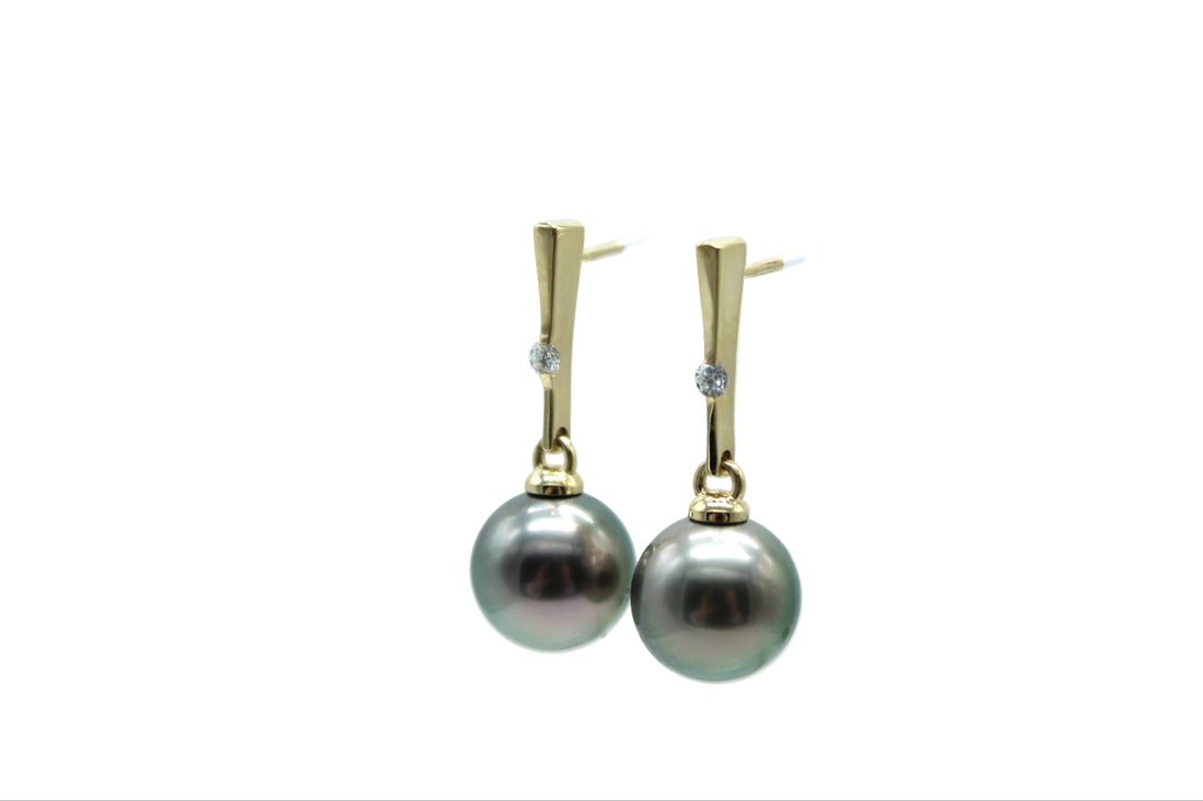 Pearl earrings with gold posts and lab grown diamonds on a white background