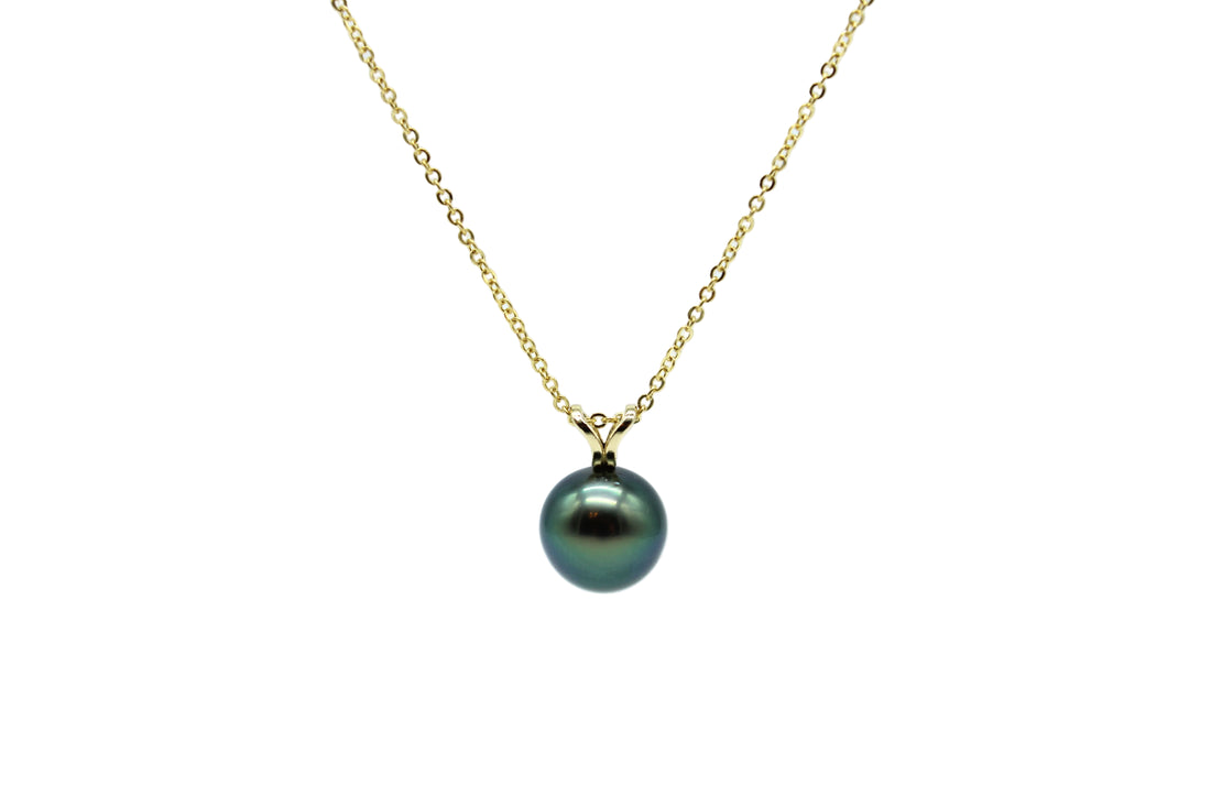 Necklace with a green pearl pendant on a gold chain against a white background