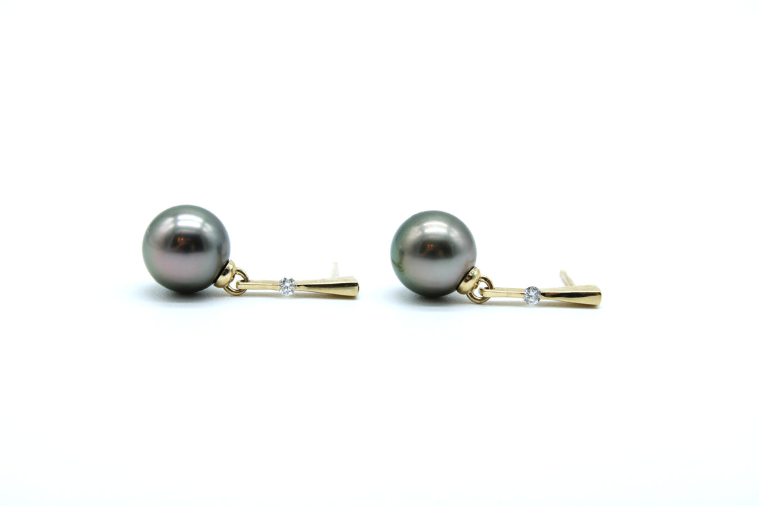 Pair of pearl earrings with gold and lab grown dangly earrings on the side with white background
