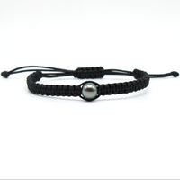 A hand braided macrame style tahitian black pearl bracelet on waxed polyester featuring a lustrous, 9mm, blue/green, tahitian pearl.