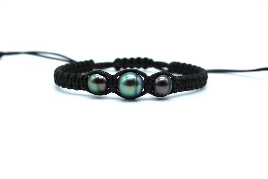 Black macrame bracelet with three pearls on a white background