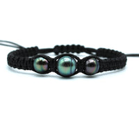 Black macrame bracelet with three pearls on a white background