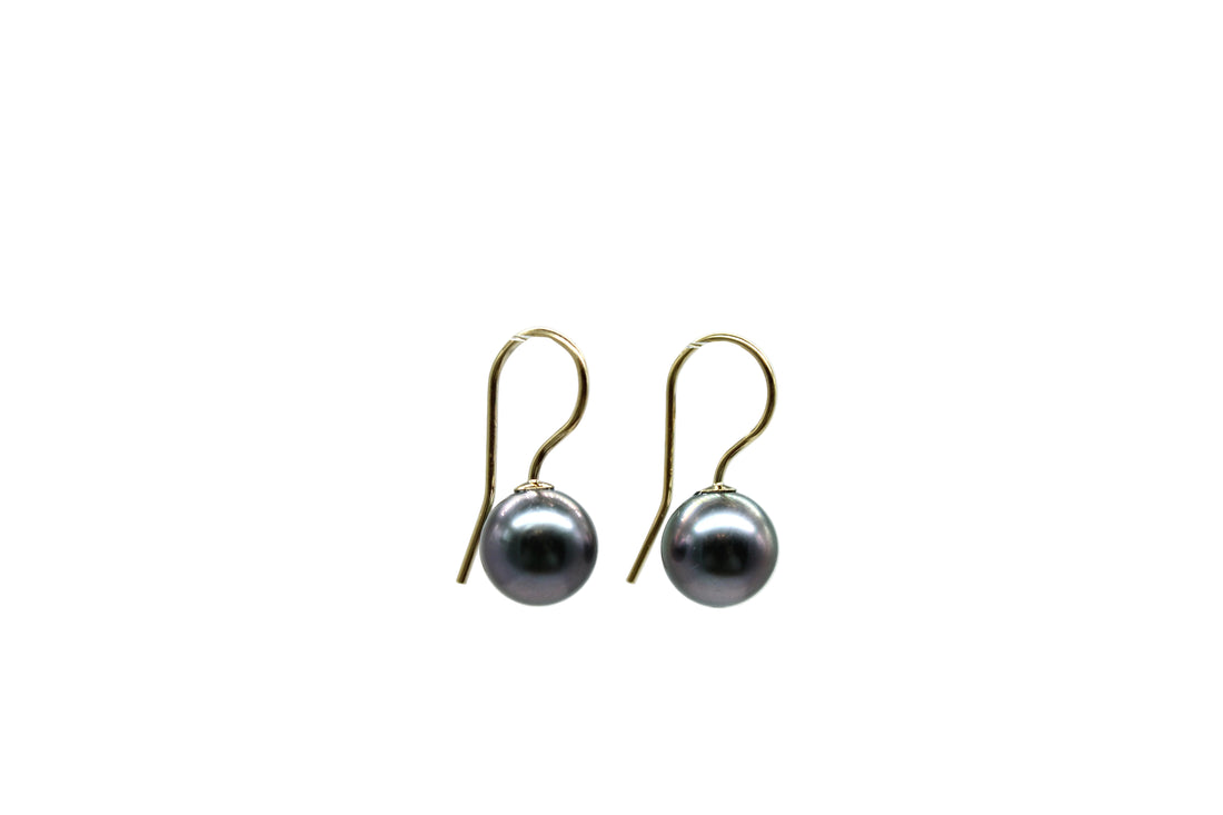 Side view of gold filled french hook earrings with Tahitian black pearls with a white background