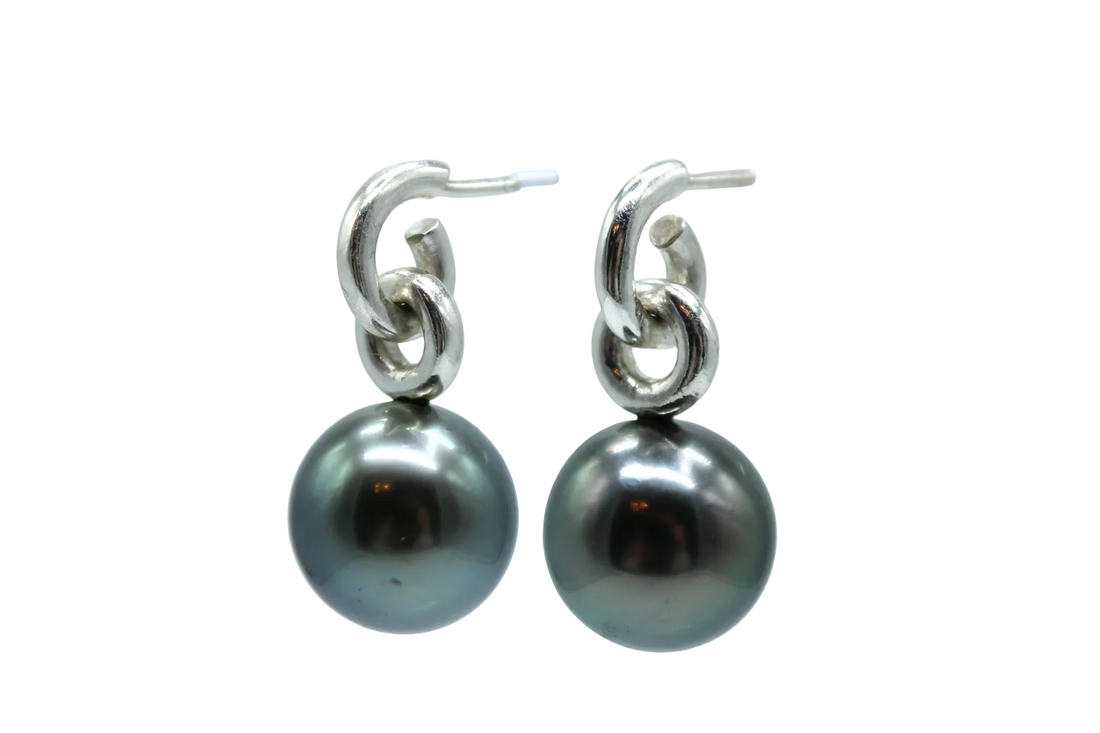 Pair of black pearl earrings with sterling silver hooks on a white background side view