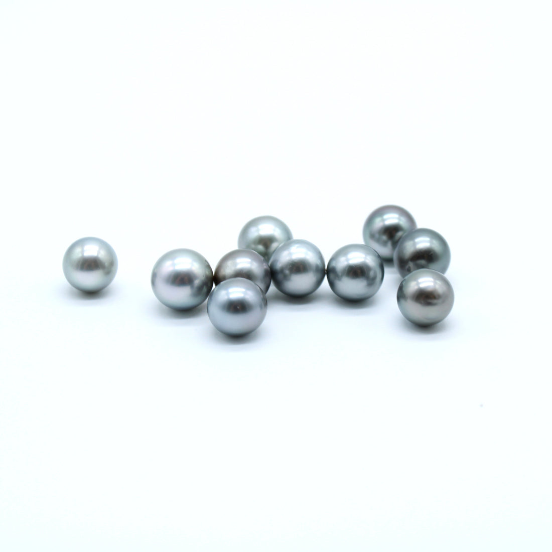 Silver Tahitian black pearls on a white background