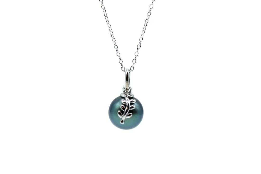 Sterling silver leaf pendant featuring a blue color tahitian black pearl on a necklace on a white background