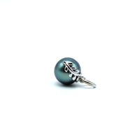 Sterling silver blue tahitian pearl pendant with a leaf design laying on the side with a white background