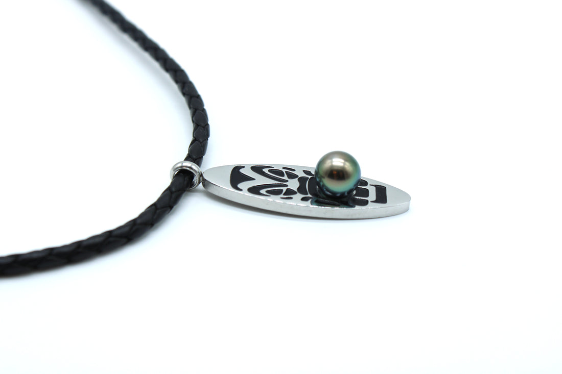 Necklace with a black cord and silver pendant featuring a pearl on a white background