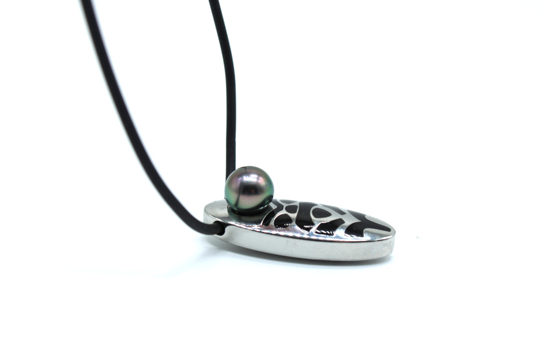 Silver pendant with a black cord and a central pearl on a white background