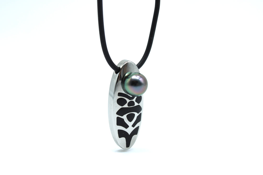 Necklace with a tiki pendant featuring a black pearl on a white background